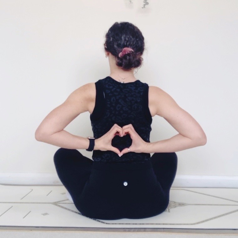 Yoga pose with heart shaped hand gesture