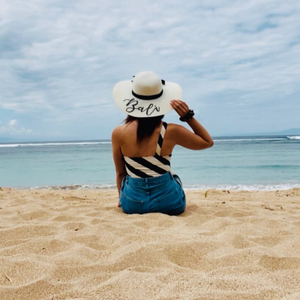Me on a beach with my Bali hat